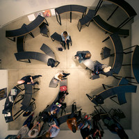 A bird's-eye view of pieces of curved furniture arranged all over the Blackwood Gallery, sometimes overlapping. People sit on and stand around the structures.