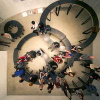 A bird's-eye view of furniture arranged in multiple interlocking circles with visitors sitting on it.