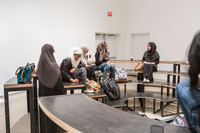 The Furnishing Position sculpture configured to resemble two semi-circular amphitheatres facing each other. People sit on the sculpture.