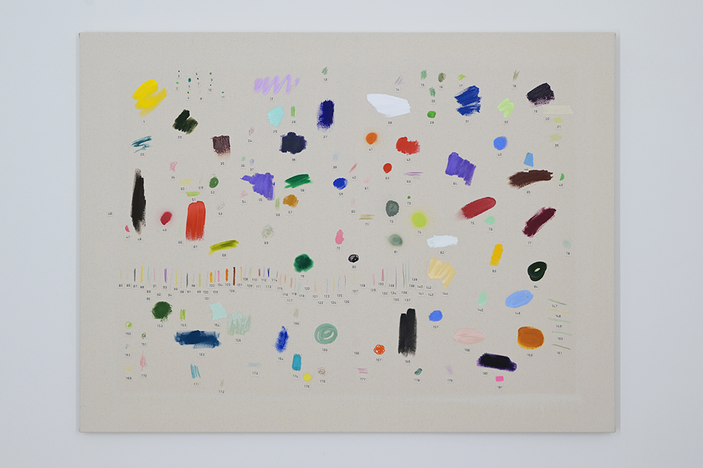 This image shows a colour enlargement of a smaller work. It is a light grey canvas which has 181 unique paintbrush markings on it. Each marking has a label underneath with a typed number. The numbering starts with 1 at the top left and orders itself in roughly 8 rows and ends with 181.  The markings are patches, circles, dabs or dashes of colour made with various sizes of paint brushes. The markings are all over the canvas and in all different colors such as green, purple, red, brown, yellow, orange and blue.