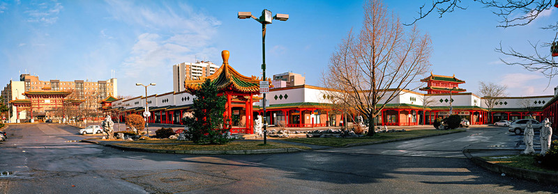 An exterior panoramic view of a Chinese restaurant with apartment buildings in the background.